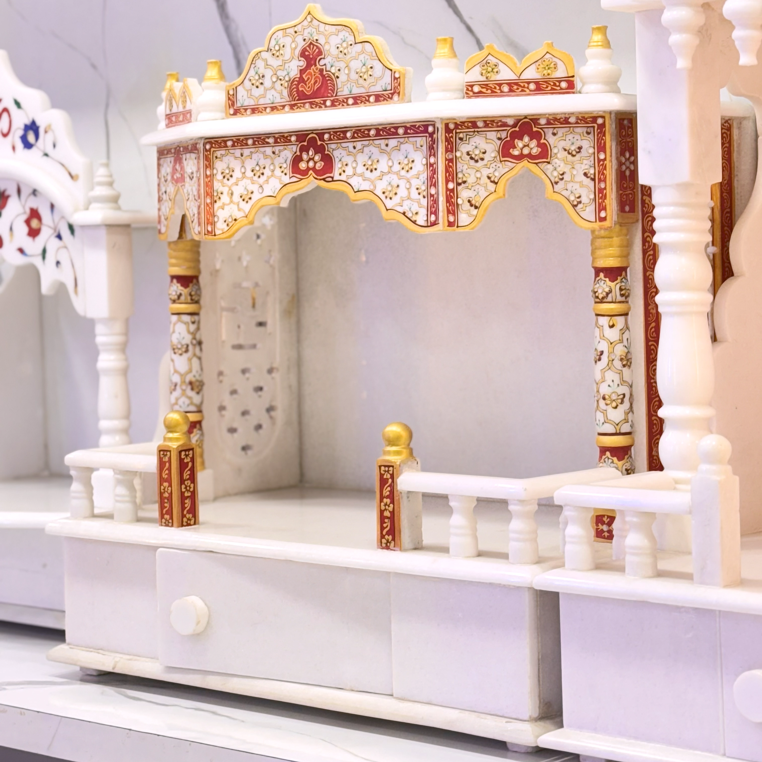 Traditional marble temple with red and gold accents