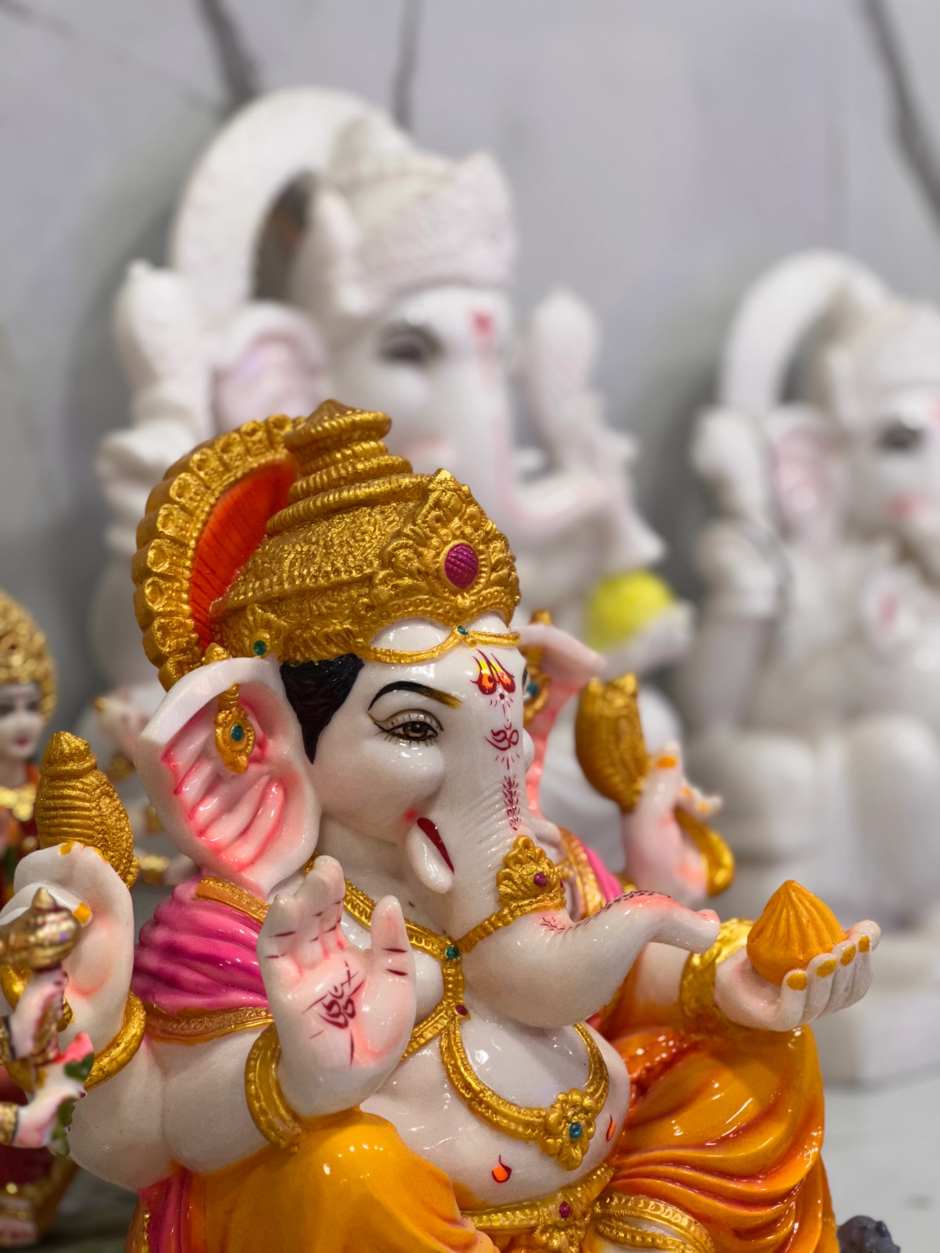 Lord Ganesha murti with red and gold accents